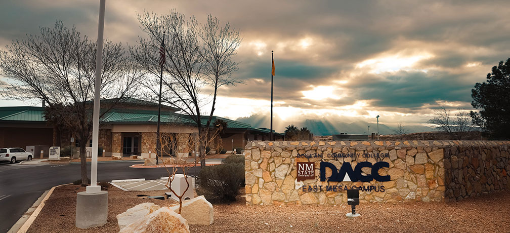 DACC East Mesa entrance with sun rays peeking through the clouds behind it.