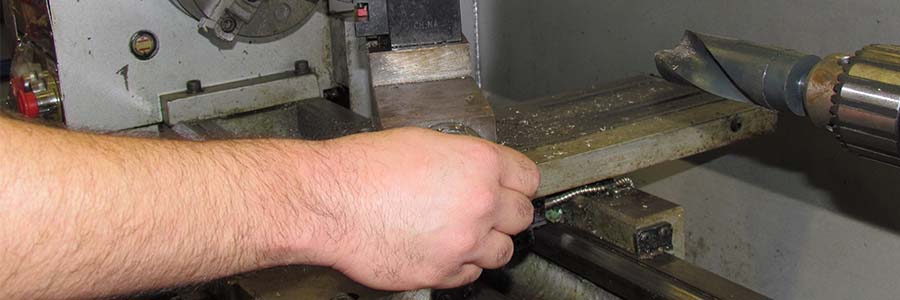 A hand adjusts a piece of machinery.