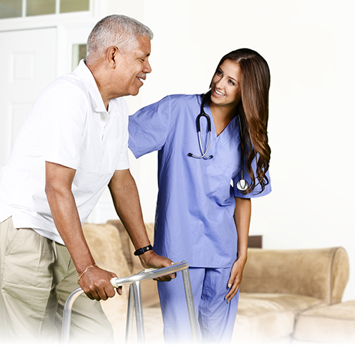 A healthcare aid walking with an elderly gentleman using a walker.