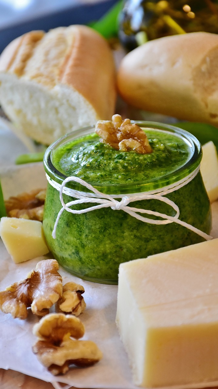 Mouthwatering, made from scratch, walnut pesto surrounded by fresh baked white bread, walnut halves, and blocks of cheese.