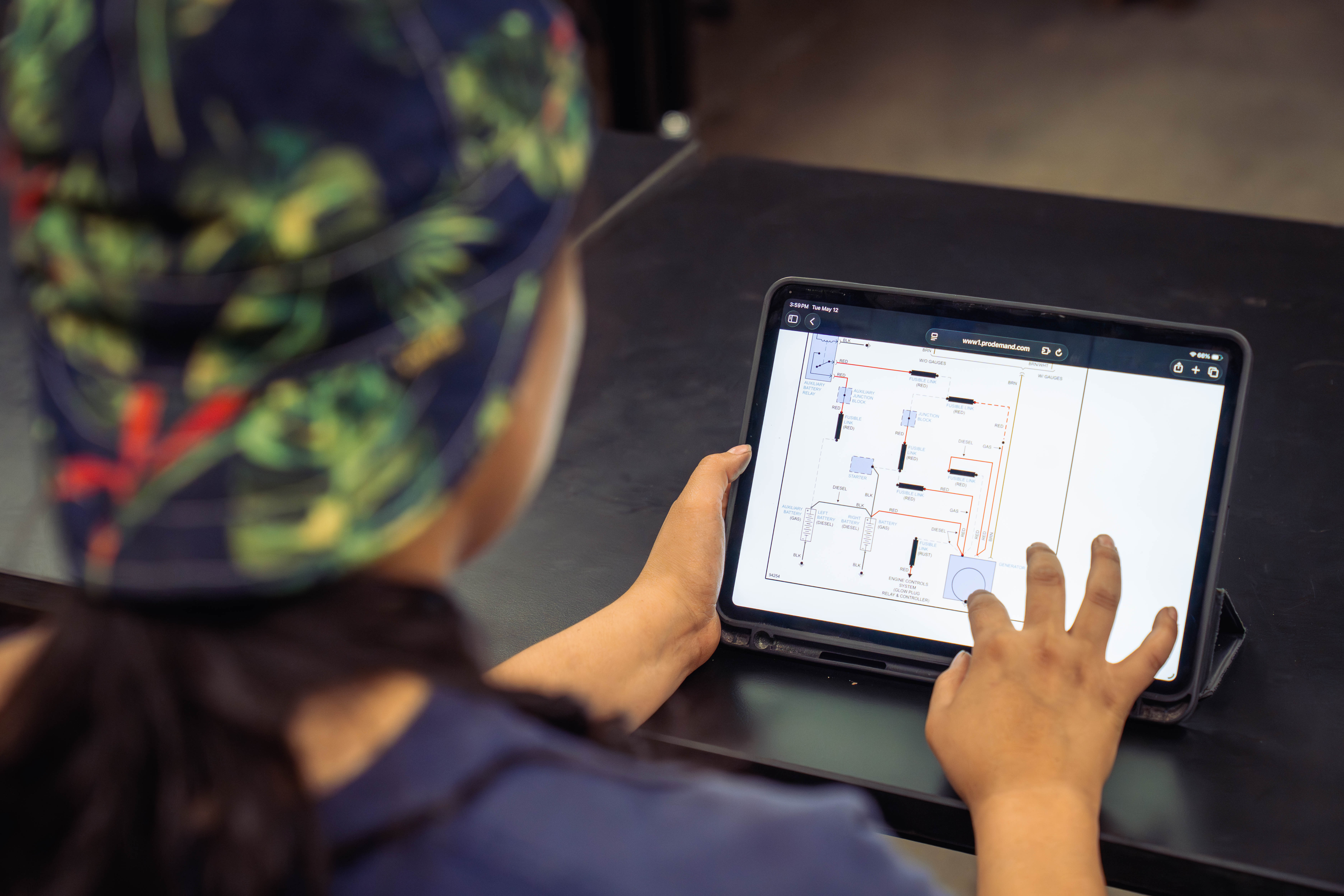 A student working on an ipad with schematics pulled up