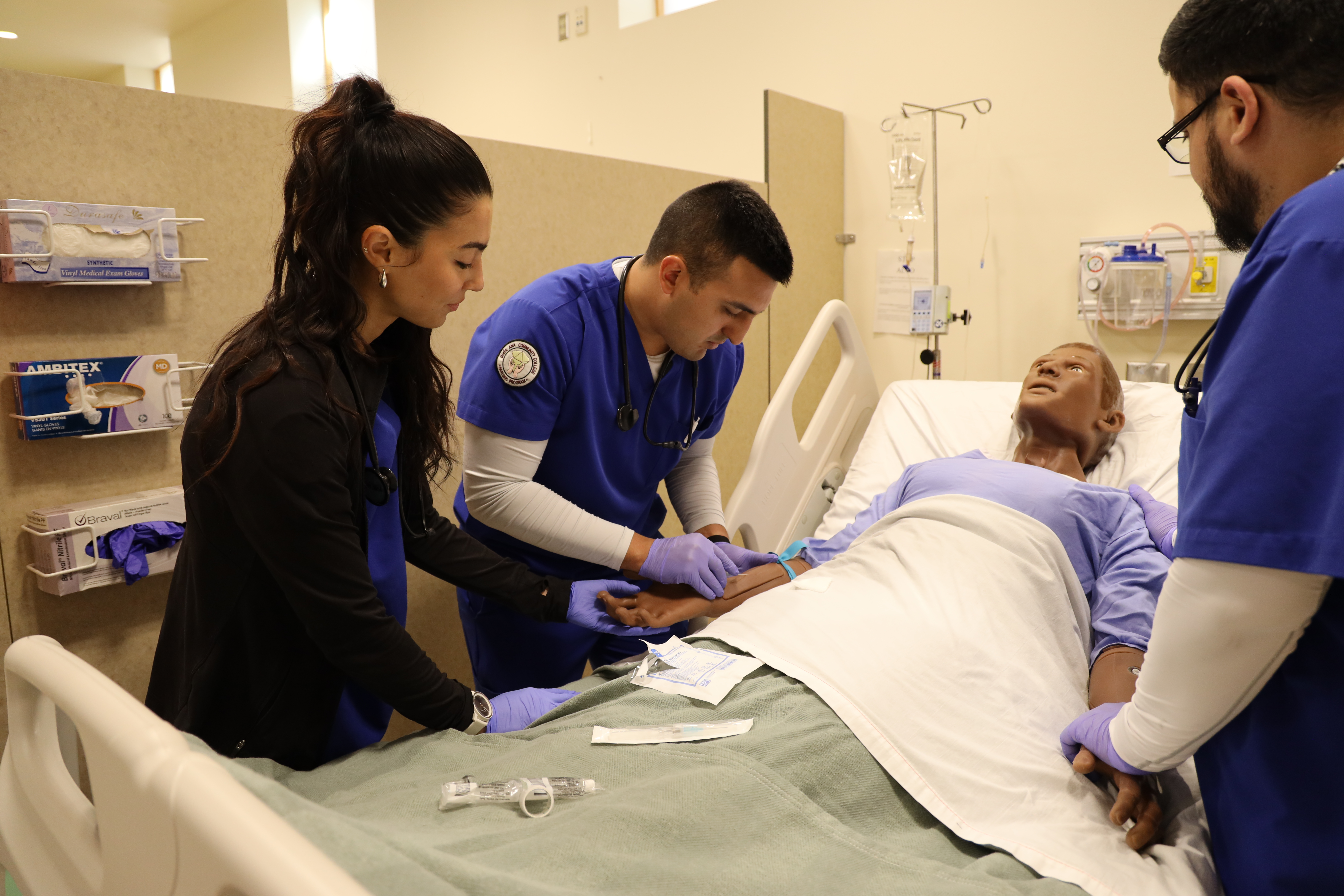   DACC Nursing students practice inserting IVs into a mannequin. The college has used simulation in its lab for several years.  